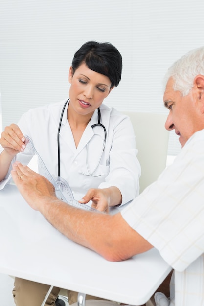 Physiotherapist examining patients wrist with goniometer