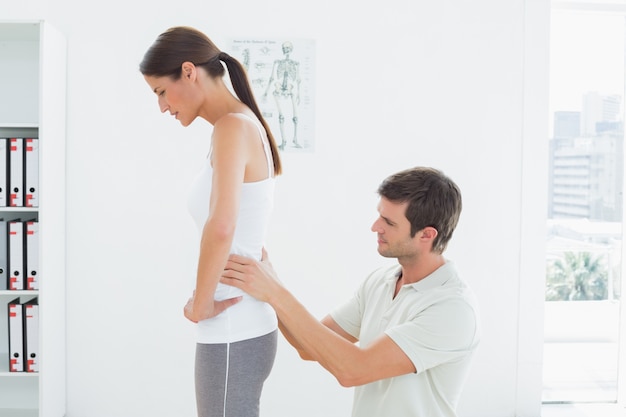 Physiotherapist examining womans back in medical office