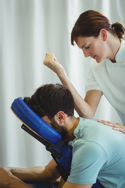 Physiotherapist giving back massage to a patient