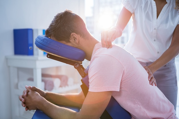 Photo physiotherapist giving back massage to a patient