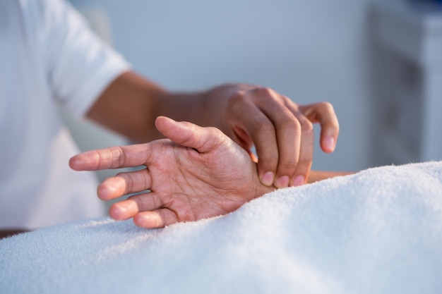 Physiotherapist giving hand massage to a woman