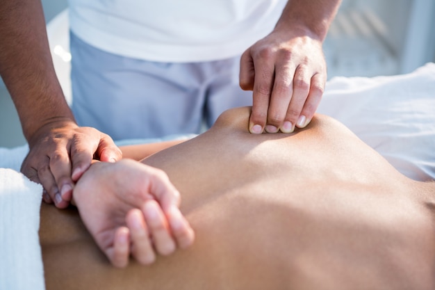 Physiotherapist giving hand massage to a woman