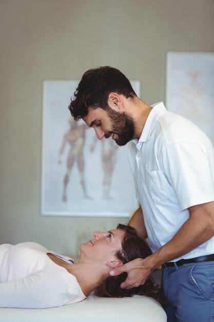 Physiotherapist giving head massage to a woman