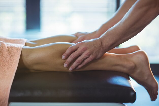 Photo physiotherapist giving leg massage to a woman