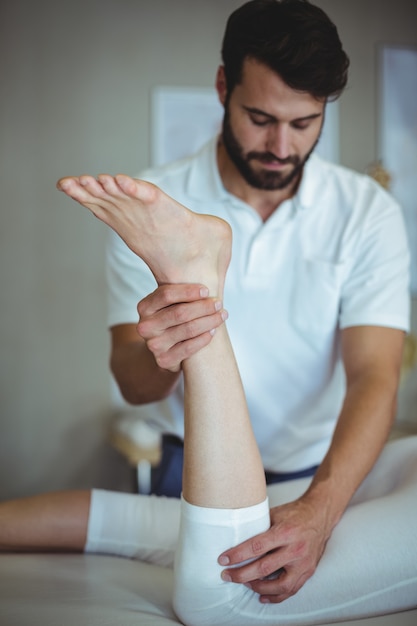 Physiotherapist giving leg massage to a woman