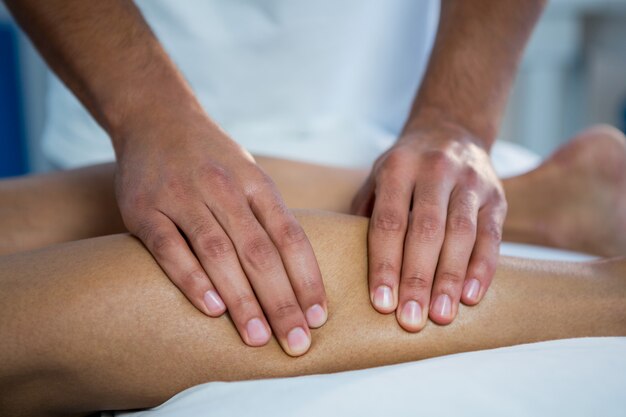 Physiotherapist giving leg massage to a woman