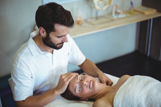 Physiotherapist giving neck massage to a woman