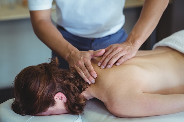 Physiotherapist giving neck massage to a woman