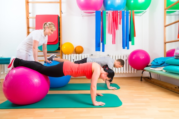 Physiotherapist giving patients gymnastic exercise