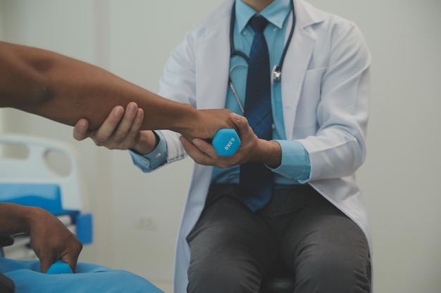 Physiotherapist man giving exercise with dumbbell treatment About Arm and Shoulder of athlete male patient Physical therapy concept