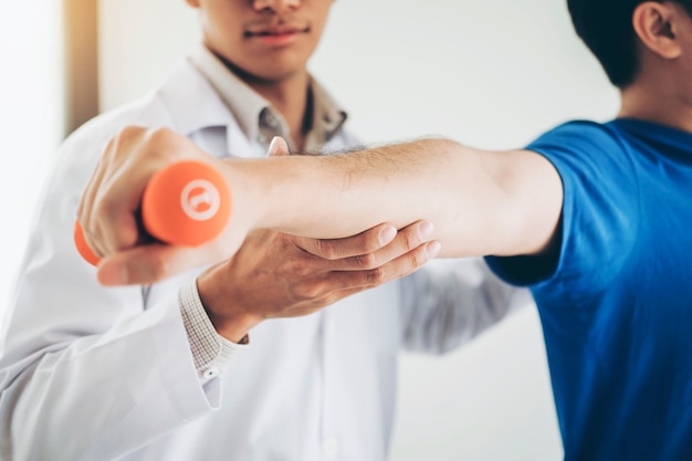 Physiotherapist man giving exercise with dumbbell treatment About Arm 