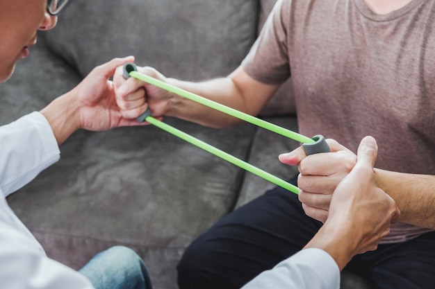 Physiotherapist man giving resistance band exercise treatment About Chest muscles