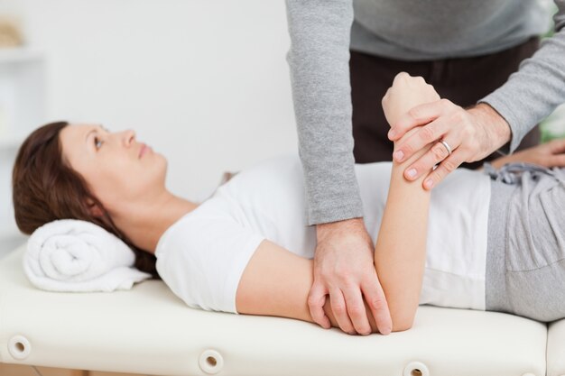 Photo physiotherapist manipulating the arm of a peaceful woman