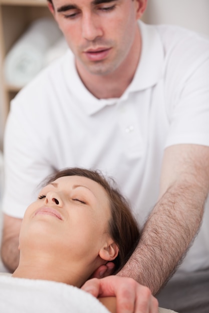 Physiotherapist manipulating the neck of his patient