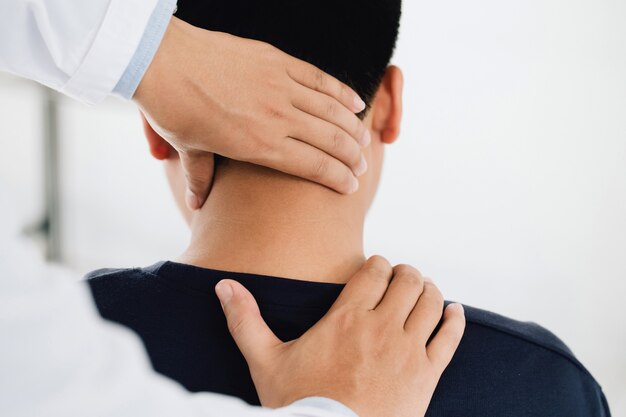 Photo physiotherapist massage therapist holding male clients head and massaging tight neck muscles