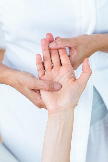 Foto fisioterapista che massaggia la sua mano dei pazienti