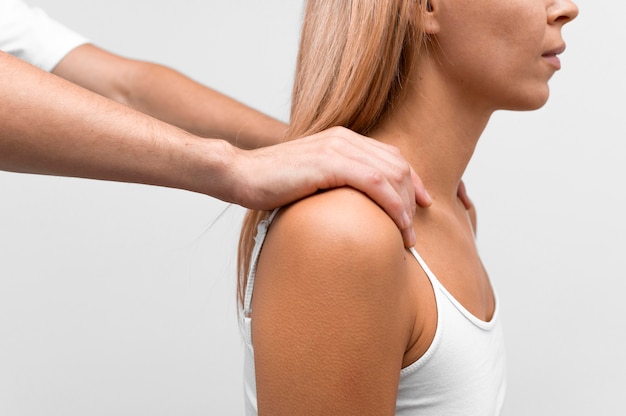 Photo physiotherapist massaging woman's shoulder