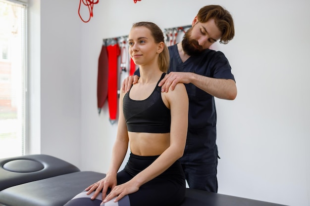 Physiotherapist orthopedist specialist examining a patient's shoulders