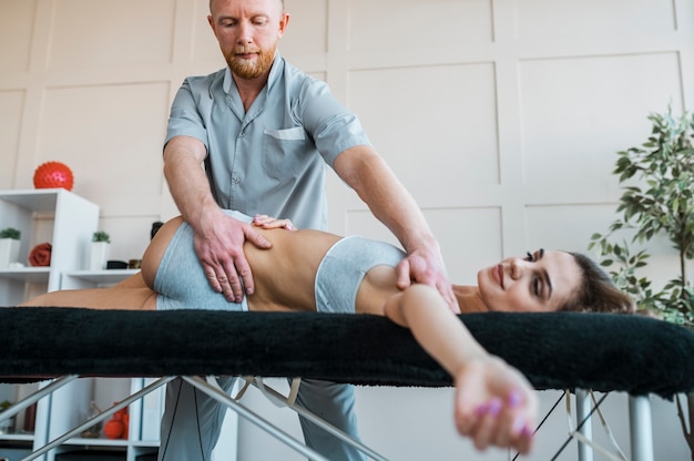 Photo physiotherapist performing physical exercises on woman