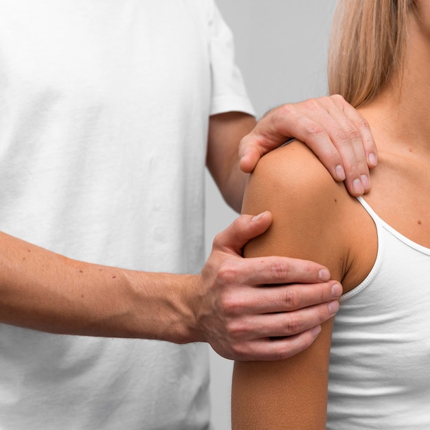 Physiotherapist performing shoulder exercises on female patient