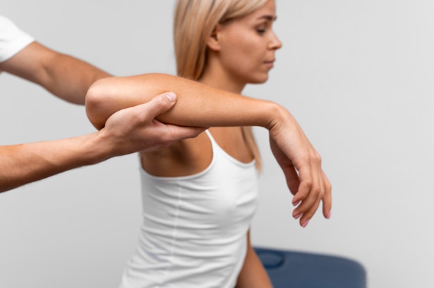 Photo physiotherapist performing shoulder exercises with female patient