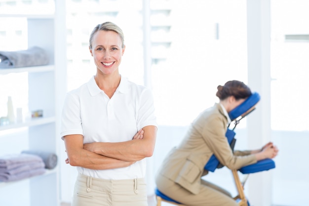 Physiotherapist smiling at camera arms crossed