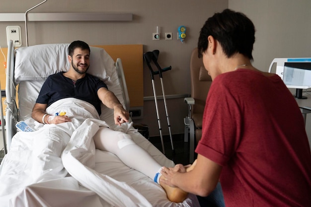 Физиотерапевт посещает пациента в больнице после операции
