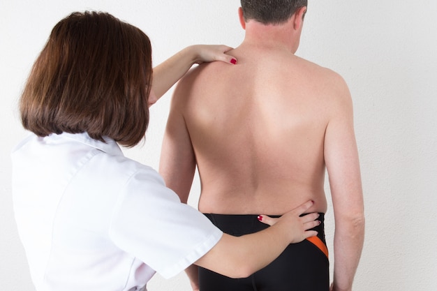 Physiotherapist woman doctor examining the patient's back