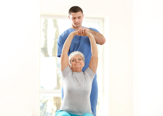 Physiotherapist working with elderly patient in clinic