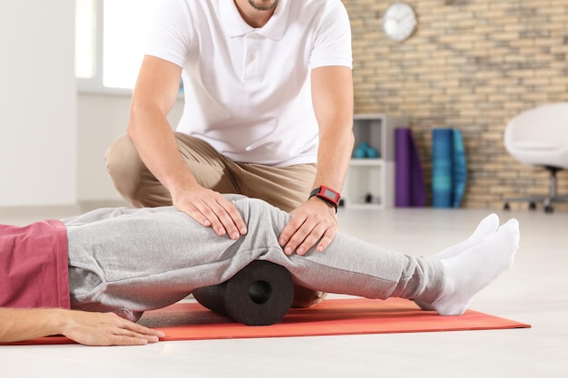 Physiotherapist working with young male patient in clinic