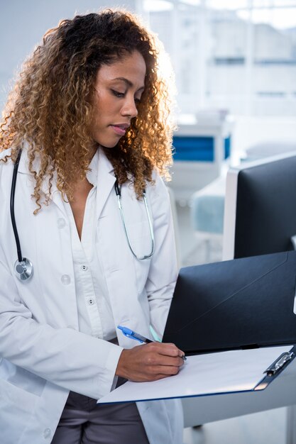 Physiotherapist writing on clipboard