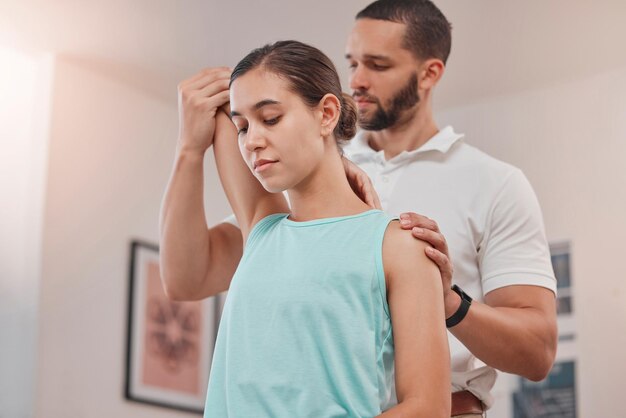 physiotherapy arm and woman consulting physiotherapist for injury problem and osteoporosis in consultation room chiropractor stretch and exam by chiropractor for bone shoulder and rehabilitation