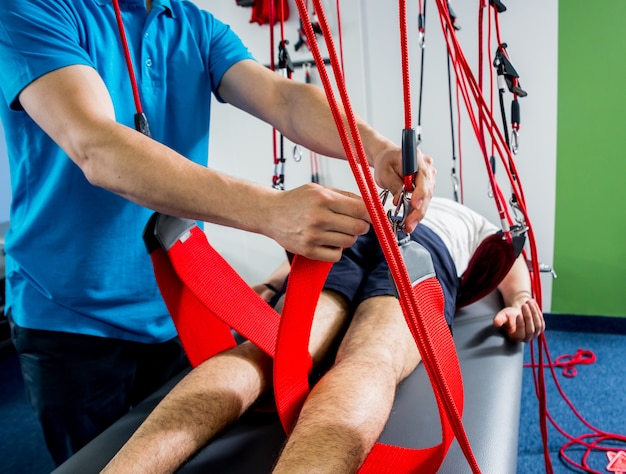 Photo physiotherapy. suspension training therapy. young man doing fitness traction