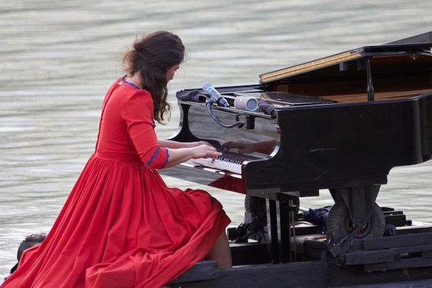 Foto pianista che suona il pianoforte al lago