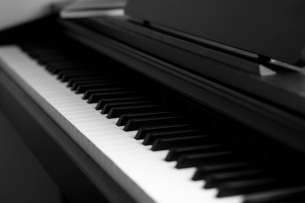 Piano en elektronisch pianotoetsenbord met zwarte achtergronden. Close-up van zwart-witte pianotoetsen, kopieerruimte, banner