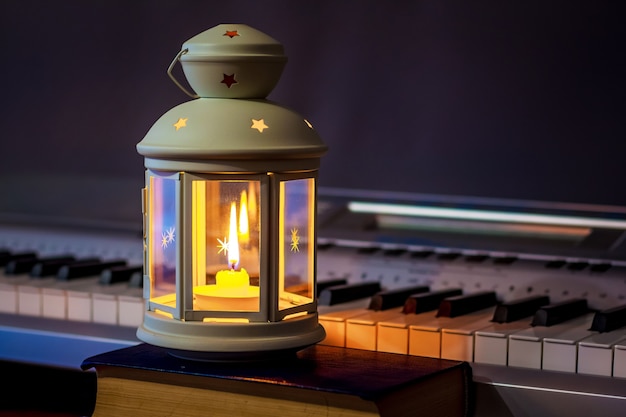 Piano in het licht van een lantaarn met kaarsen in de avond