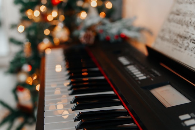 Foto tastiera di pianoforte con luci di natale luminose sullo sfondo