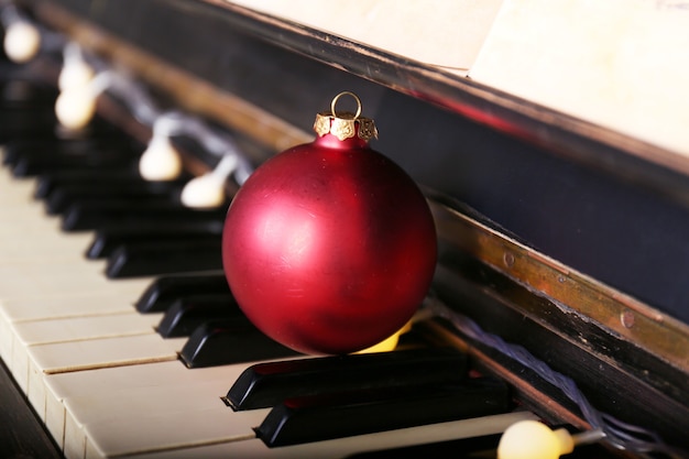 デコレーションライトと赤いボールで飾られたピアノの鍵盤、クローズアップ
