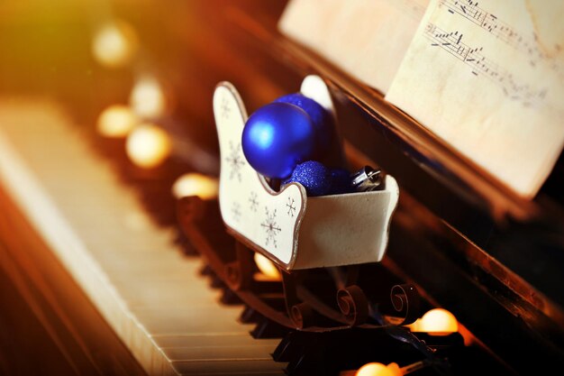 Piano keys decorated with decorative lights and balls, close up