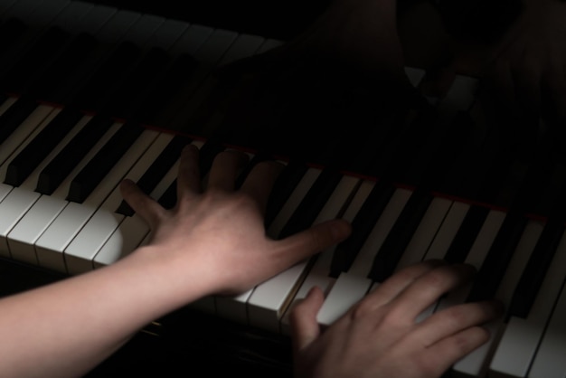 ピアノの鍵盤ピアニストの手でクラシック音楽を演奏するクローズアップ