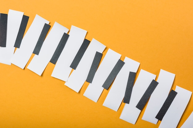 Foto pianotoetsen gemaakt met zwart-wit papier op gele achtergrond