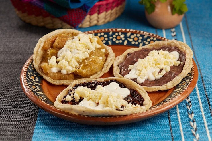 Picadas de frijol salsa de chicharron chile seco con crema y queso fresco comida mexicana