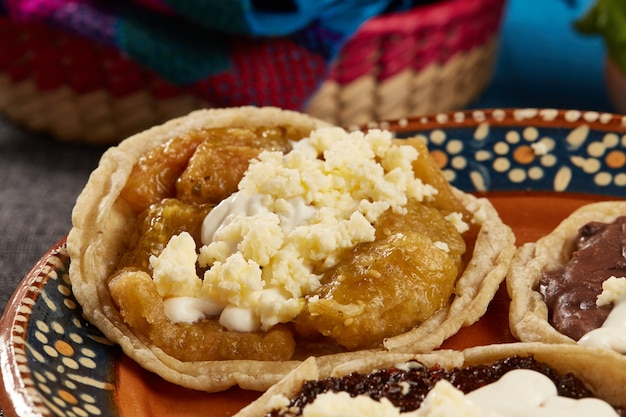 Picadas  de frijol salsa de chicharron chile seco con crema y queso fresco comida mexicana