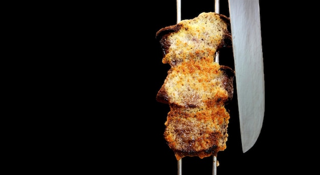 Picanha Brazilian traditional steak in barbecue Slices of grilled Picanha with garlic in red background with copy space