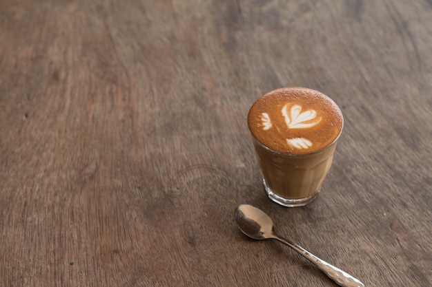 Piccolo Latte art in small glass on wooden desk