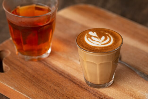 Piccolo Latte art in small glass on wooden desk