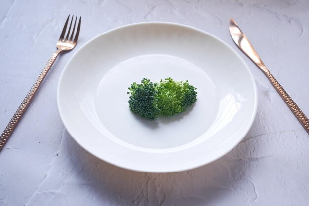 Picking raw broccoli with fork