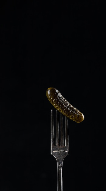 A pickle is pricked on a fork