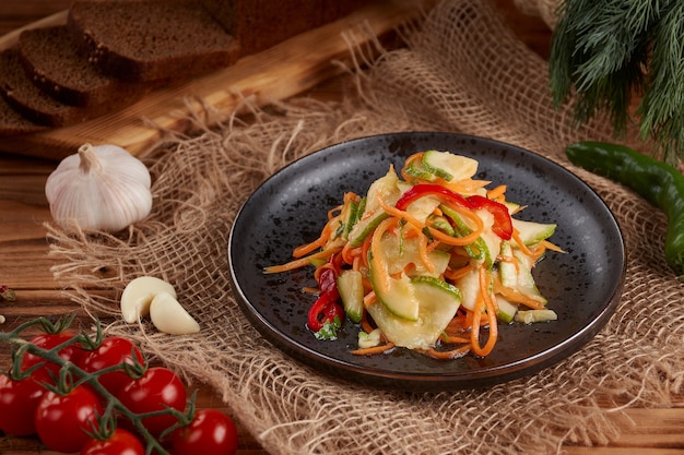 Pickled cucumber salad with carrots, wooden