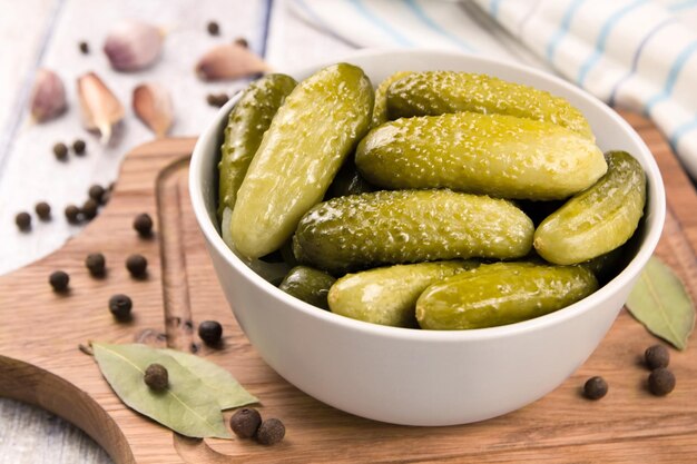 Pickled cucumbers in a bowl on a wooden rustic table